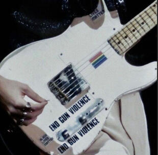 Achillean couple holding a paper with "our love is not a crime" and two hearts.